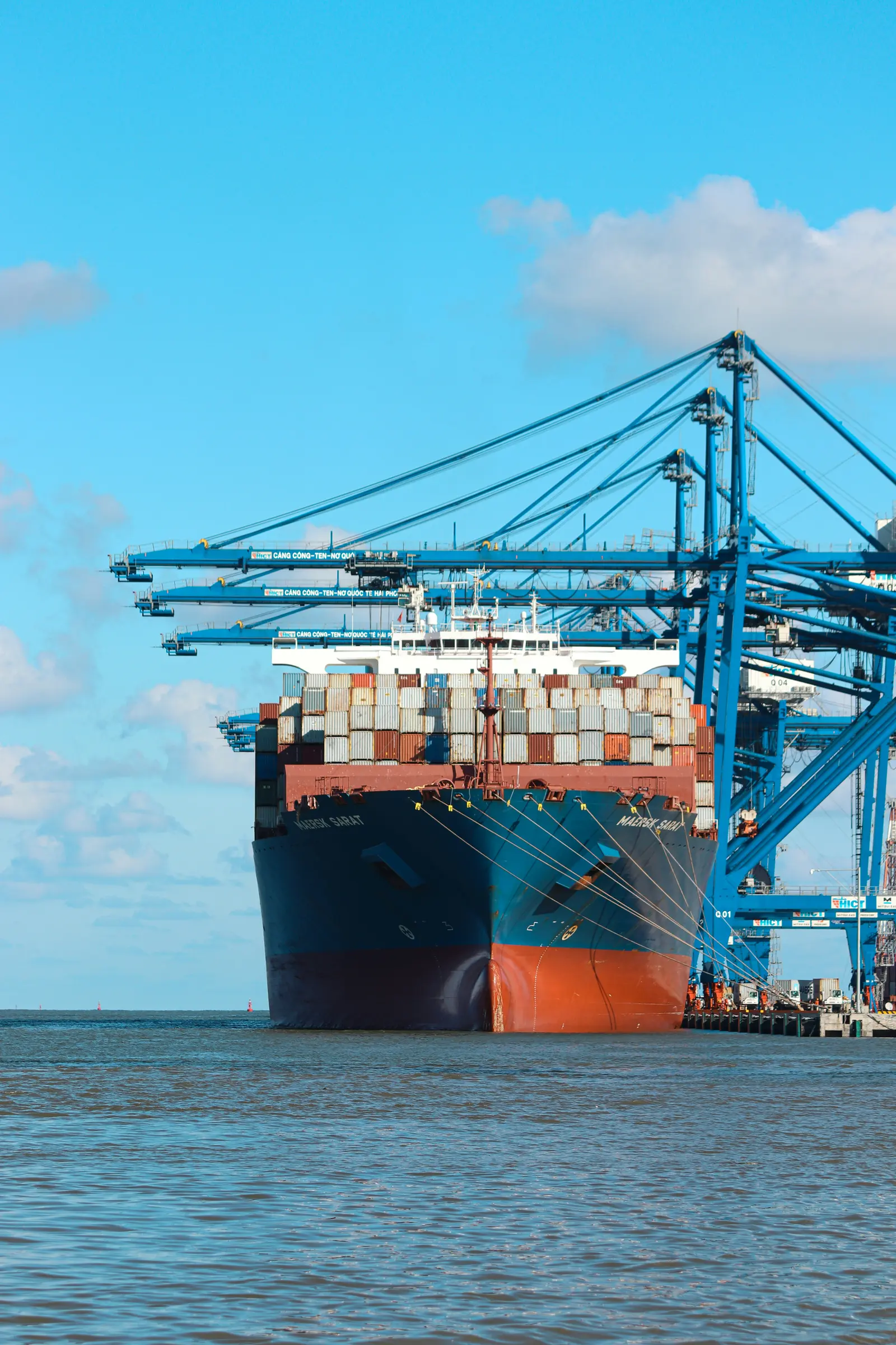 Contenedores apilados en una terminal portuaria, vistos desde abajo